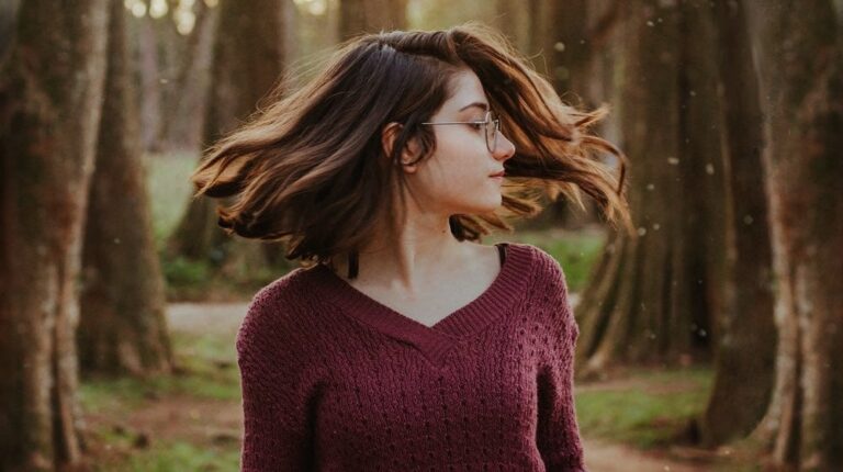 woman-waving-hair | How To Grow Out Natural Hair Color Seamlessly | Featured