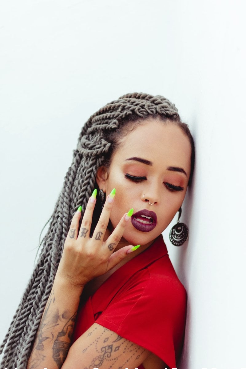 woman with braided hair leaning on wall | undercut girl
