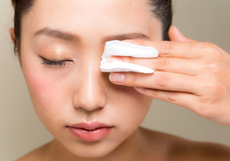 young woman removing makeup cotton | best pillowcase to prevent wrinkles